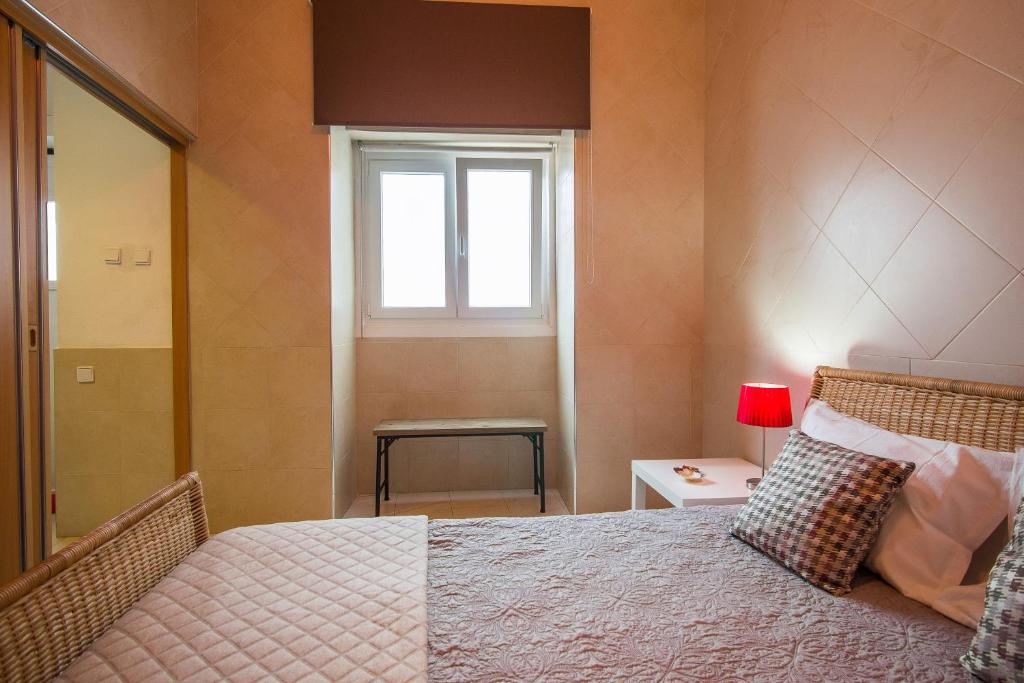 a bedroom with a large bed with a window at #DuplexduBocage com vista lateral para a Praça in Setúbal