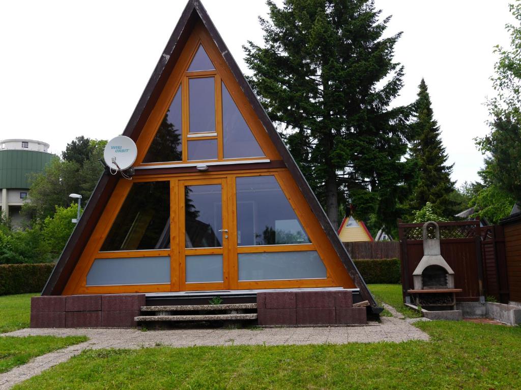 Schellbronn的住宿－Ferienhaus im Nordschwarzwald - Nurdachhaus in Waldrandlage Haus Florine，草上有一扇窗户的小房子