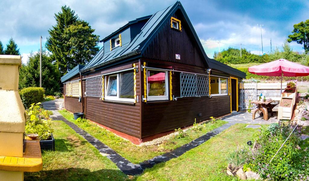 une petite maison avec un toit noir dans l'établissement Bellevue Aschberg, à Klingenthal