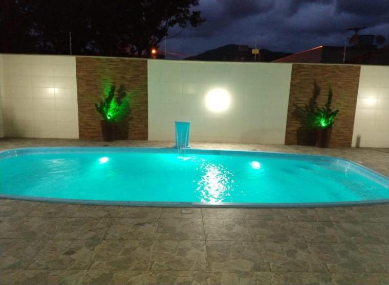 a swimming pool in a yard at night at Casa com piscina in Porto Belo