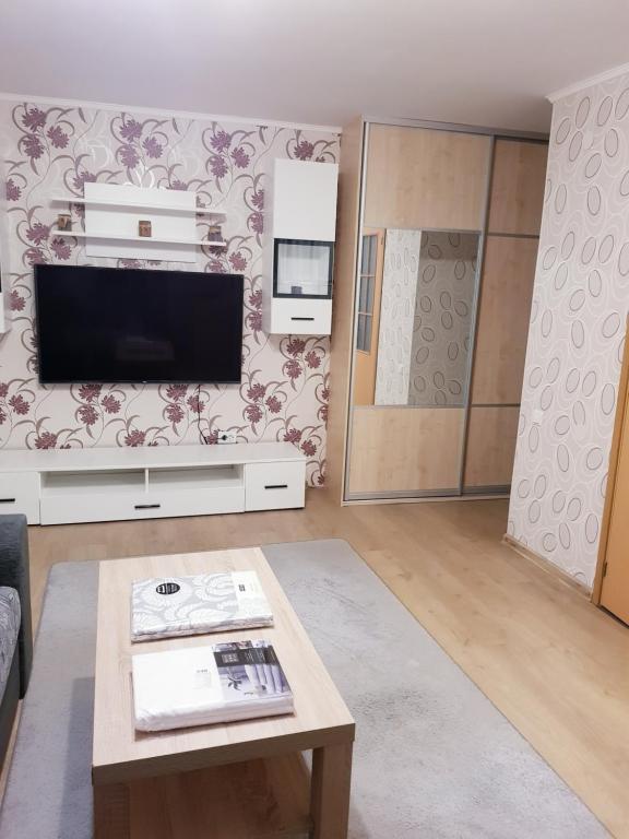Narva mnt 23 في جوفي: غرفة معيشة مع تلفزيون وطاولة قهوة
