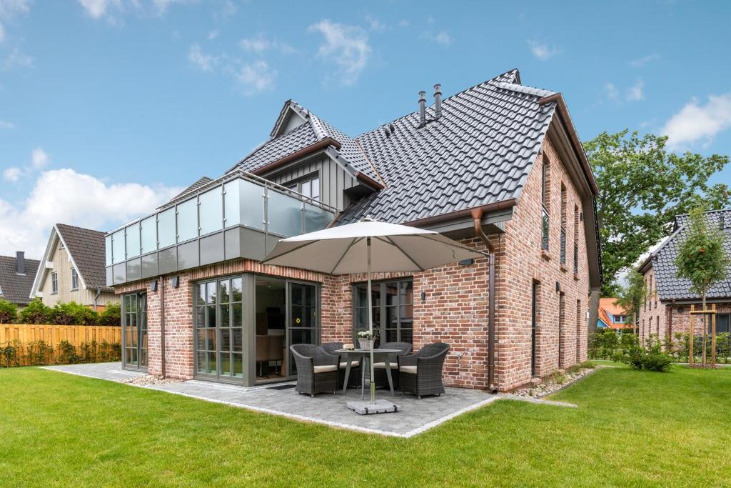 a brick house with a patio with an umbrella at Ostseereise in Zingst
