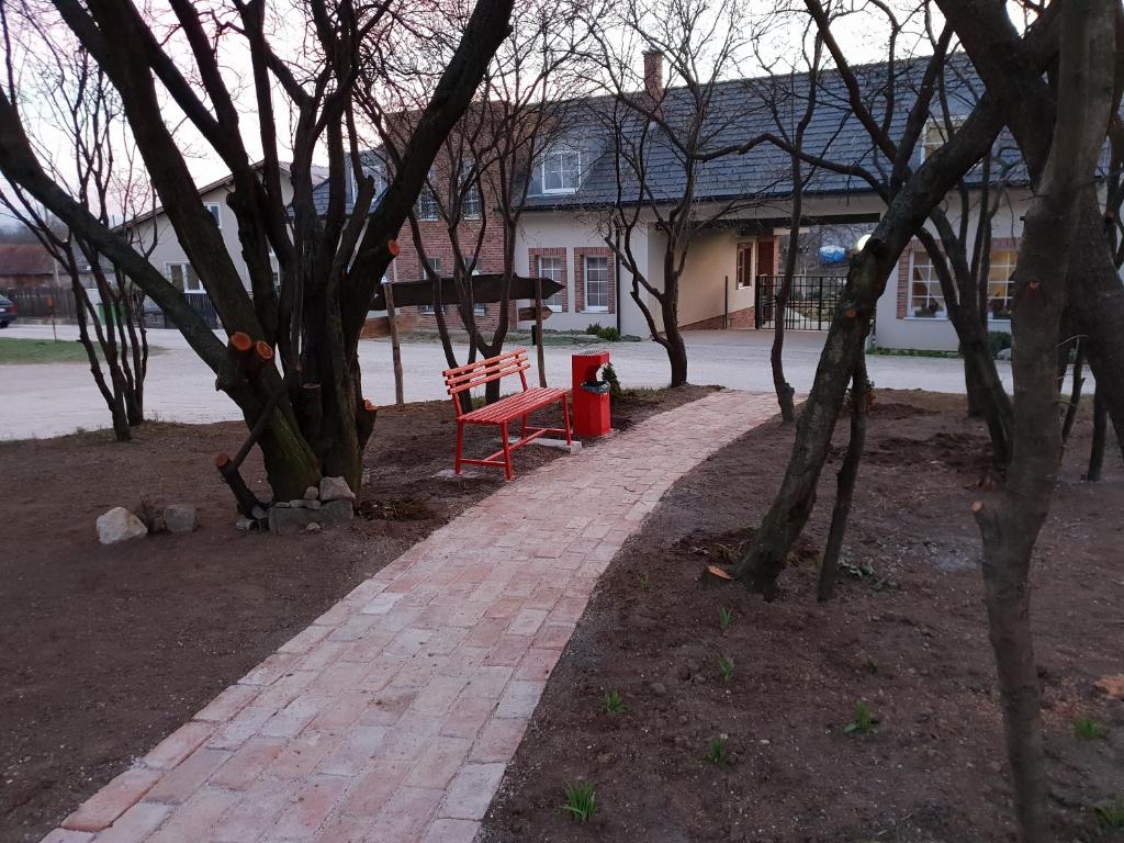 a red bench sitting on a brick path in front of a house at u Ďurkových in Žabokreky nad Nitrou