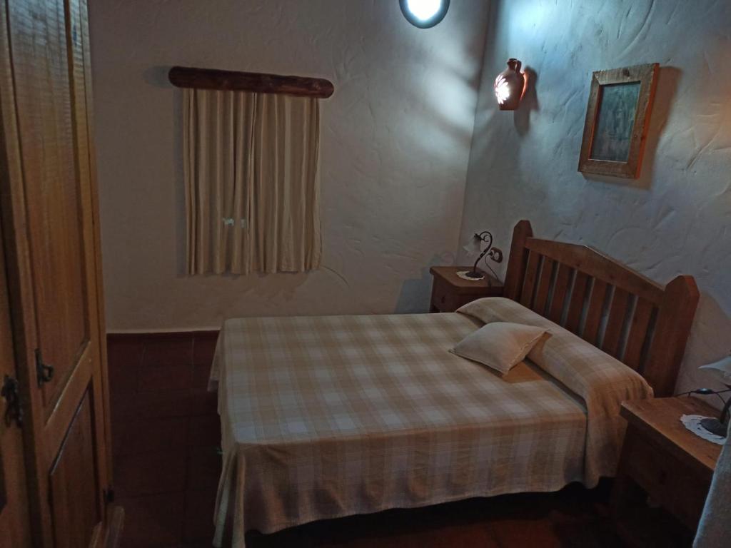 a small bedroom with a bed and a window at Las 4 Lunas in Zahara de la Sierra
