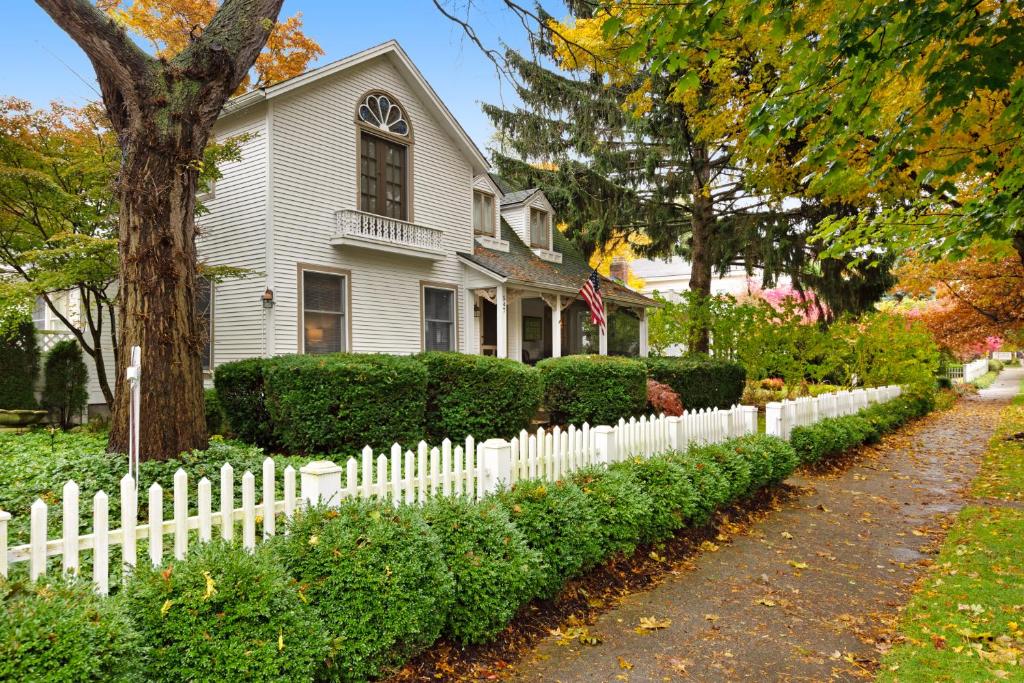 a white picket fence in front of a house at Butlers Quarters in Saugatuck