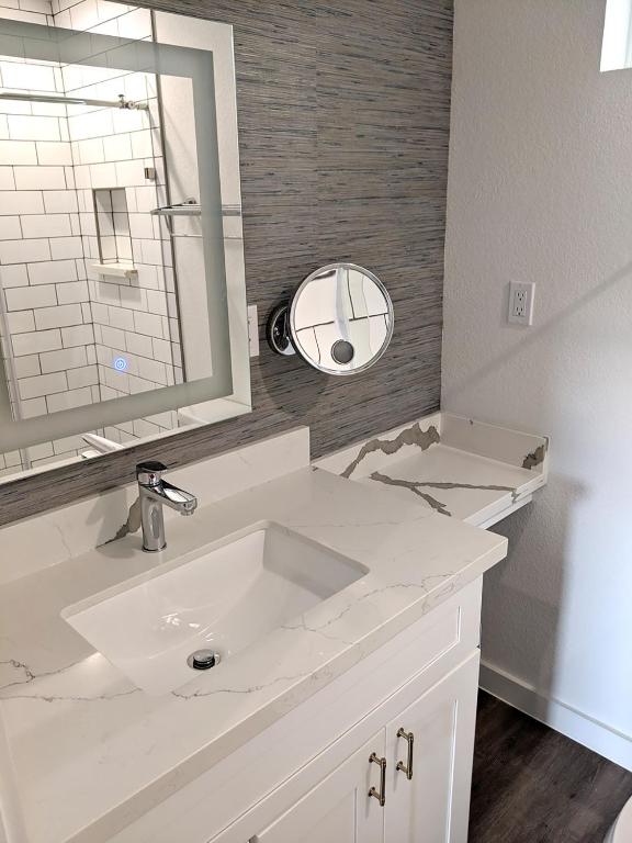 ein weißes Badezimmer mit Waschbecken und Spiegel in der Unterkunft Seaside RV resort in Seabrook