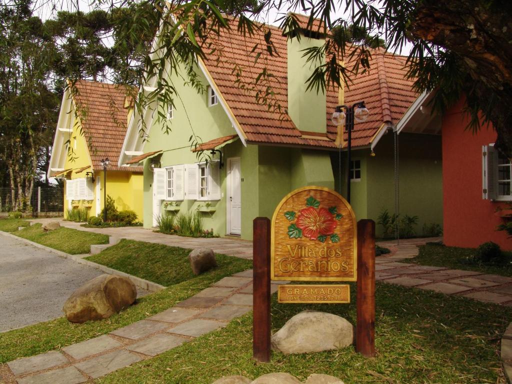 a sign in the grass in front of a house at Villa dos Geranios in Gramado