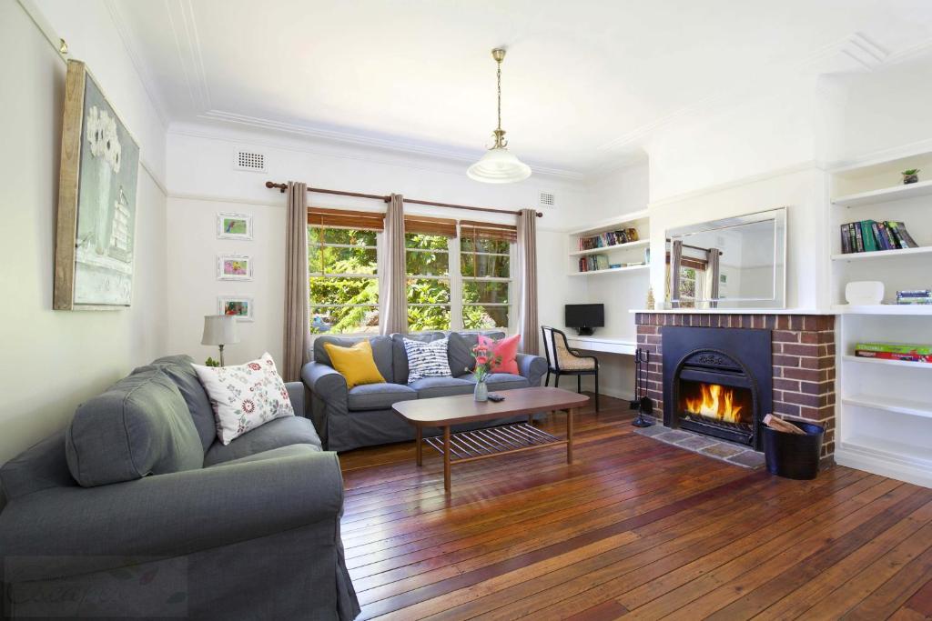 Una sala de estar con un sofá y una chimenea. en Rodova Cottage, en Katoomba