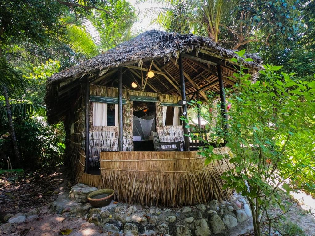 une petite maison avec toit de chaume dans l'établissement Rimba Resort - Dive Centre & Spa, à Pulau Sibu