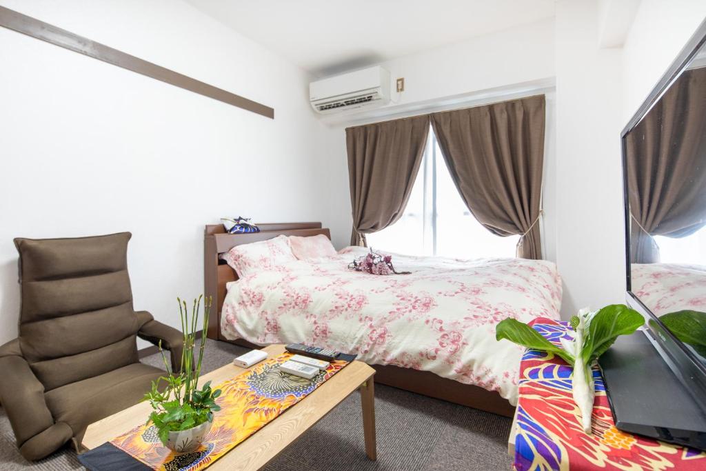 京都市にあるCozyhouse 310 free wifi a rented electric bicycleのベッドルーム1室(ベッド1台、椅子、テーブル付)