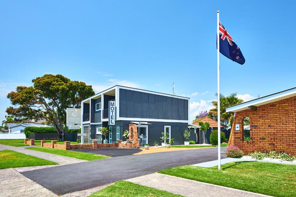a flag flying in front of a building at Cobblestone Court Motel - Wenzel Motels in Tauranga