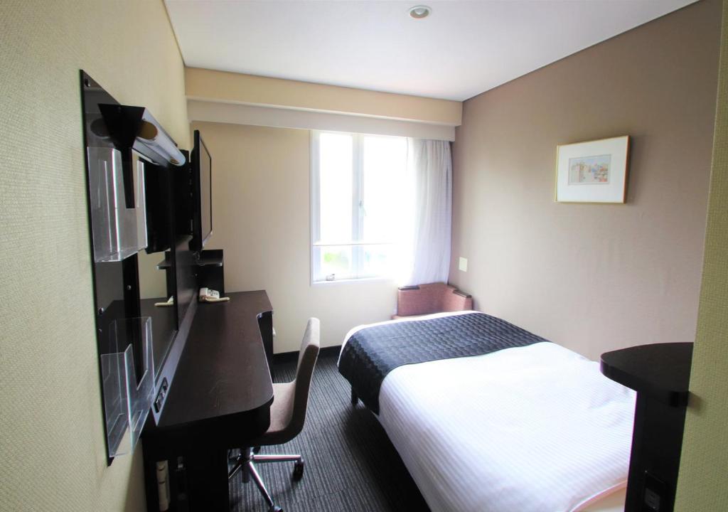 a hotel room with a bed and a desk at APA Hotel Hiroshima Ekimae in Hiroshima