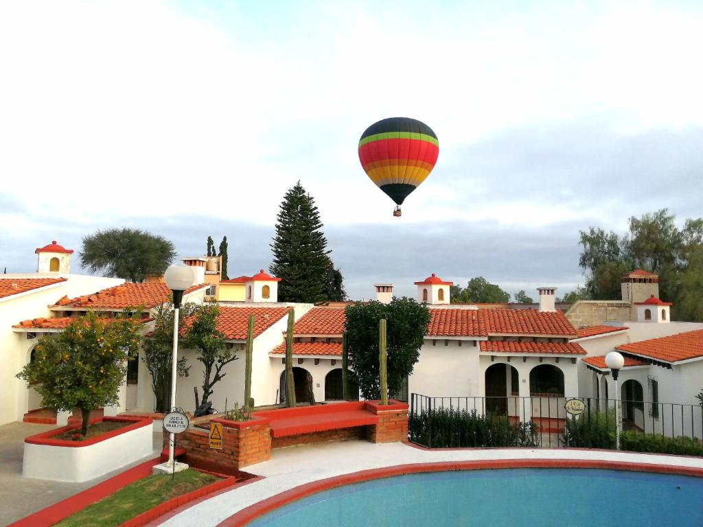 a hot air balloon flying over a house at Villas Tequisquipan in Tequisquiapan
