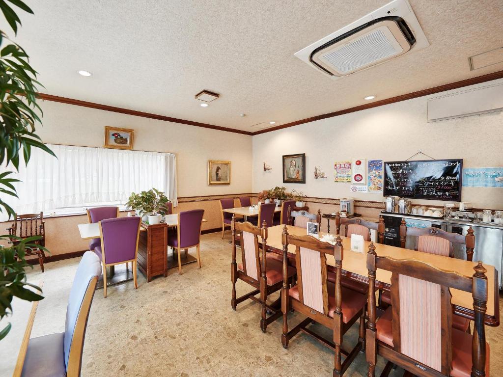 a dining room with tables and purple chairs at Crown Hotel Okinawa in Okinawa City