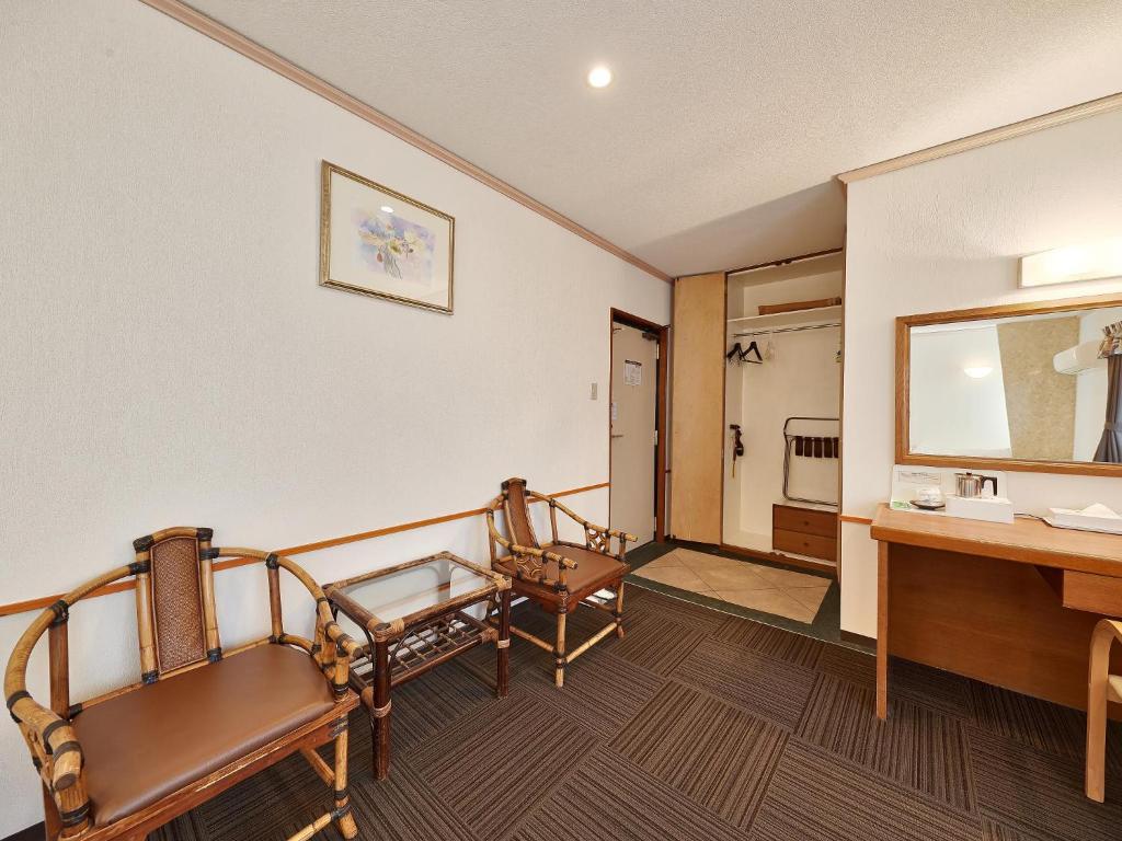 a bathroom with two chairs and a sink and a mirror at Crown Hotel Okinawa in Okinawa City