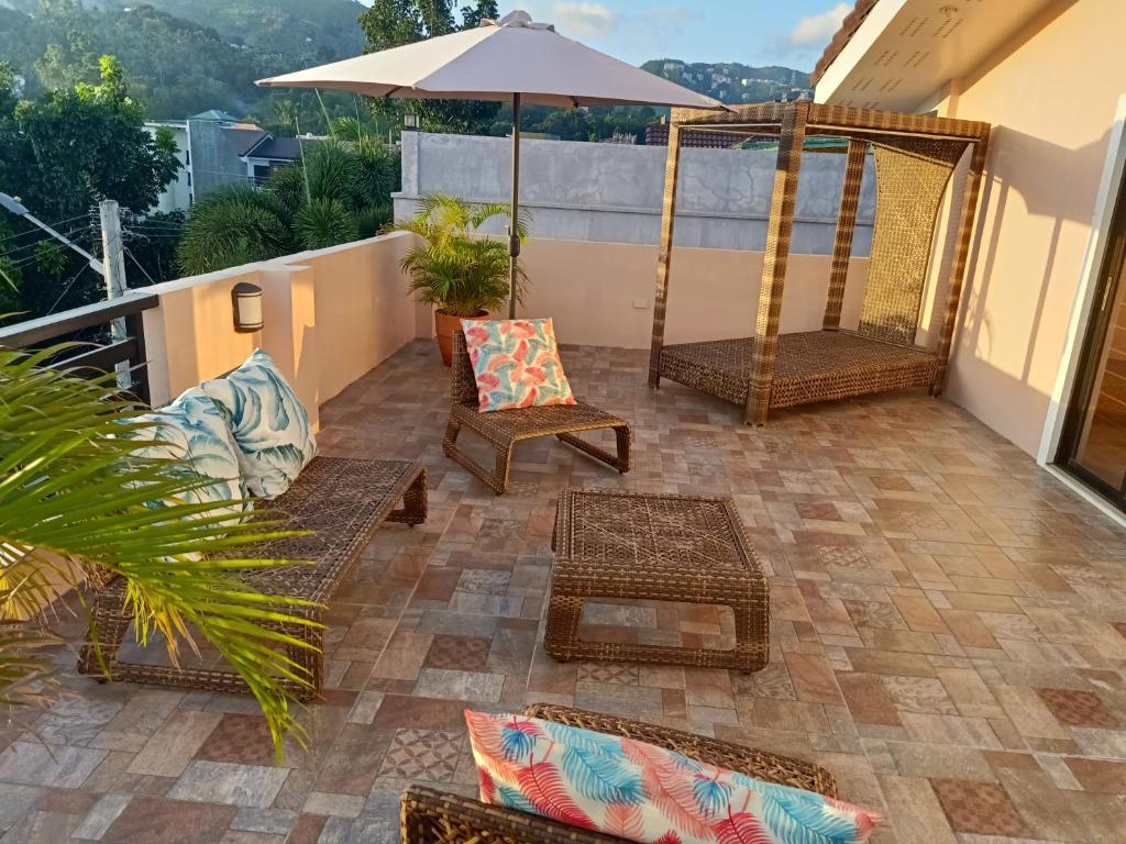 een patio met stoelen en een parasol op een balkon bij AJ's Haven Homestay in Cebu City