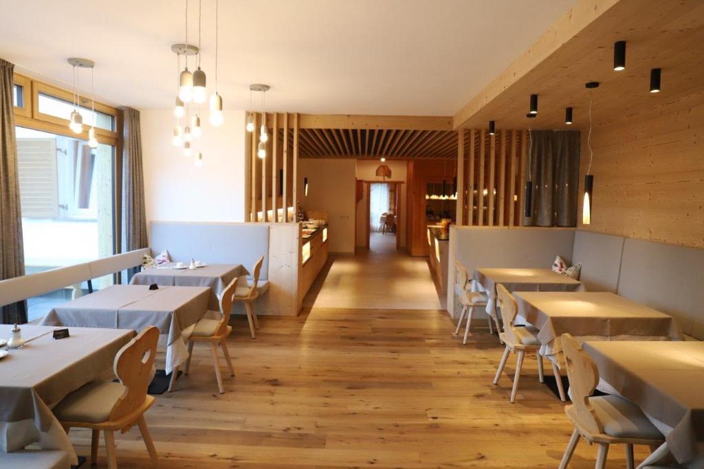 サン・ヴィジリオ・ディ・マレッベにあるLüch da Gronesのテーブルと椅子が備わるレストラン