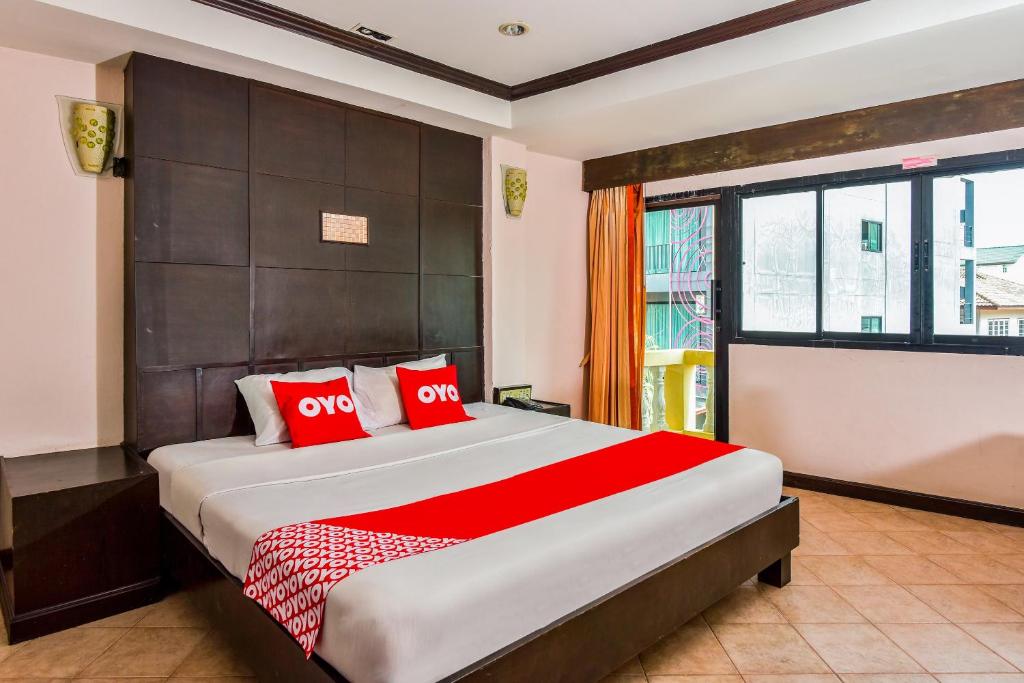 a bedroom with a large bed with red pillows at OYO 447 Royal Express Hua Hin in Hua Hin