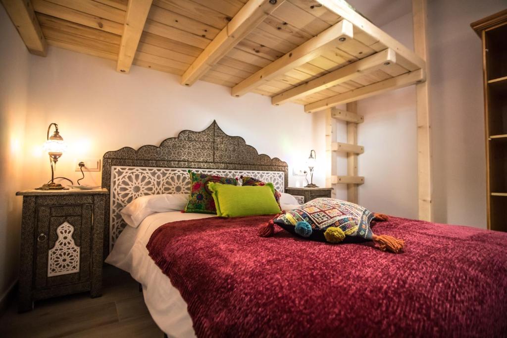 - une chambre avec un grand lit et un couvre-lit rouge dans l'établissement MULHACEN, à Sierra Nevada