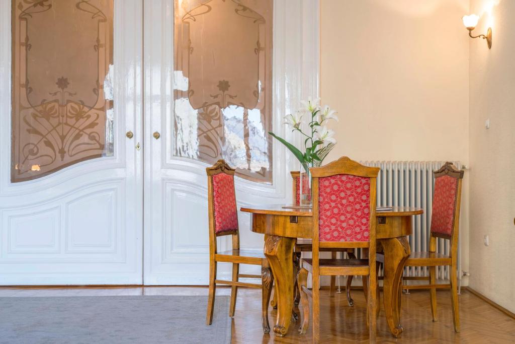 uma sala de jantar com mesa e cadeiras em Stunning spacious art nouveau apart , grand piano em Budapeste