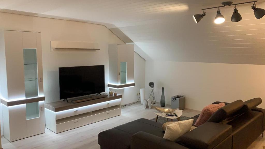 sala de estar con sofá y TV de pantalla plana en Haus Fasanenweg en Mutlangen