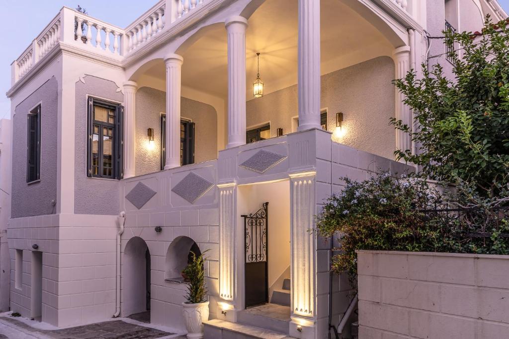 a white house with an arch and a gate at CAMARA SUITES in Andros