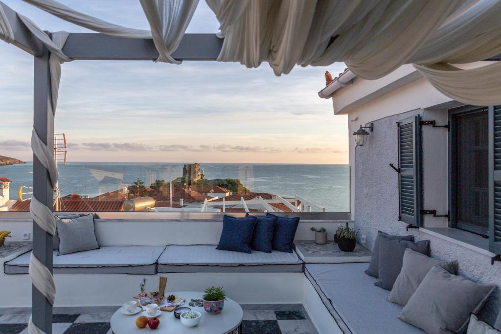 a patio with a couch and a view of the ocean at CAMARA SUITES in Andros