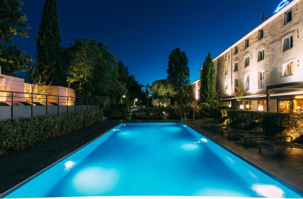 una piscina di fronte a un edificio di notte di Escale Oceania Aix-en-Provence ad Aix en Provence