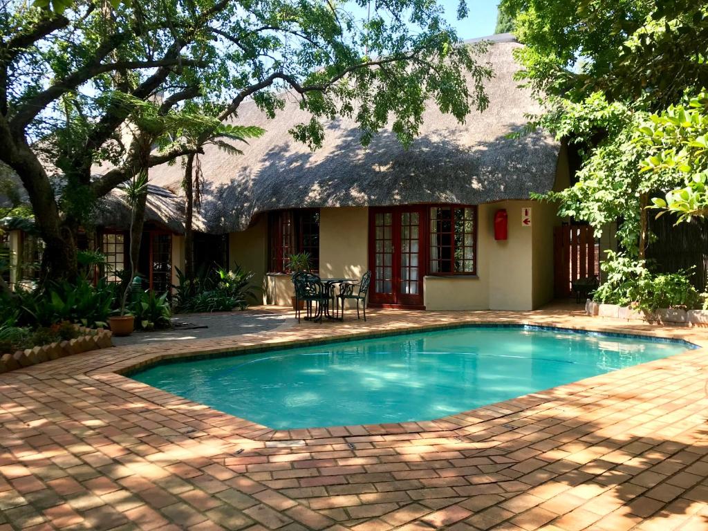 a swimming pool in front of a house at Greenwoods Self-Catering in Pretoria