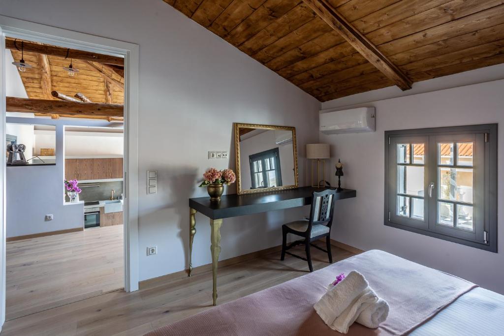 a bedroom with a desk and a mirror at CAMARA SUITES in Andros