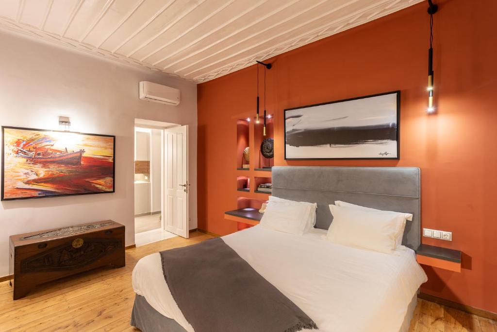 a bedroom with a large bed and a tv on the wall at CAMARA SUITES in Andros
