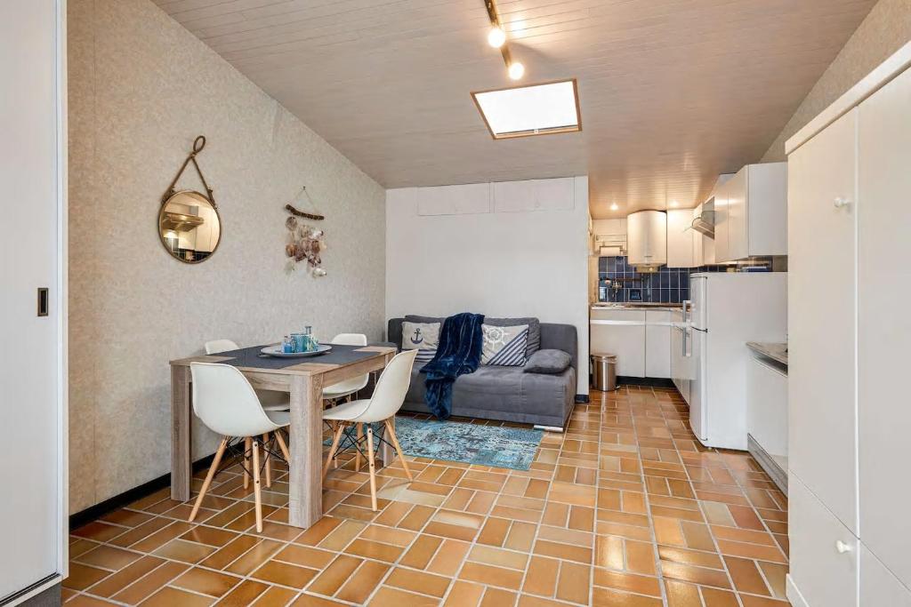 een keuken en een woonkamer met een tafel en stoelen bij AMAZING BEACH & SUNSETS JUST 75m FROM THE BEACH! in Cadzand-Bad