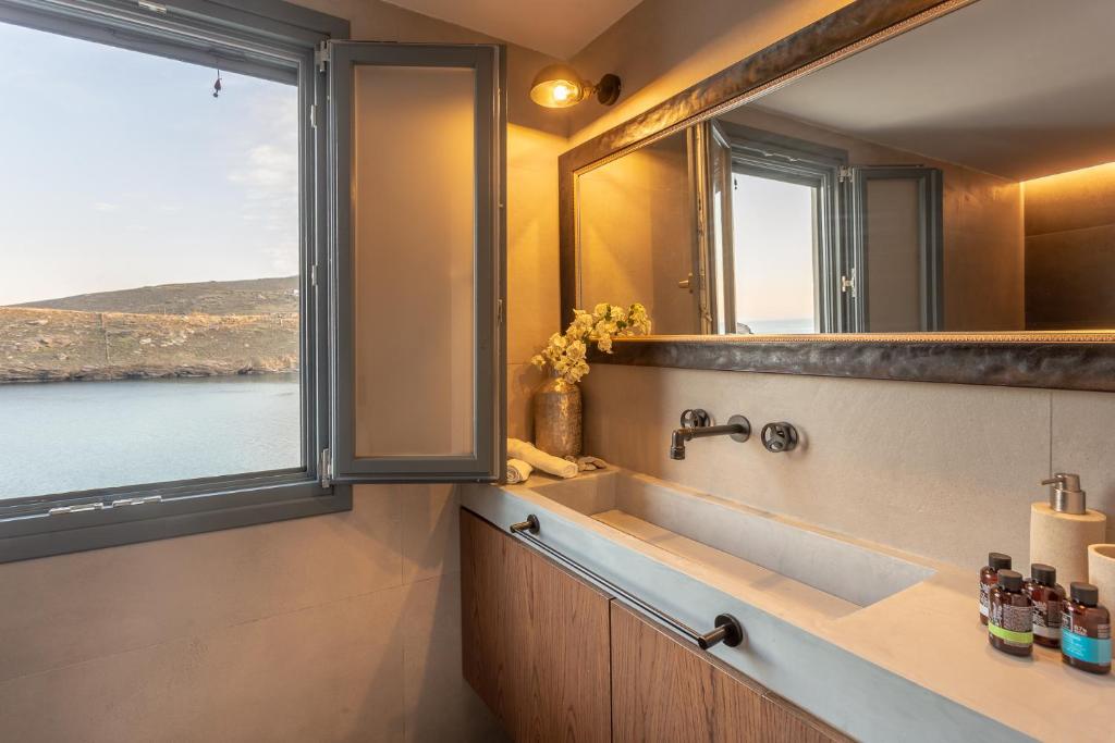 a bathroom with a sink and a large window at CAMARA SUITES in Andros