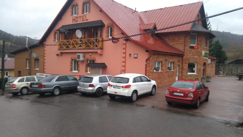 a group of cars parked in front of a building at Hotel Koloniál Skalité in Skalité