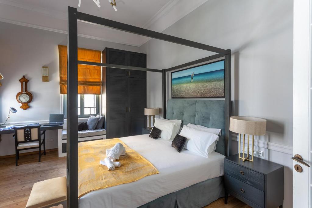 a bedroom with a large bed and a desk at CAMARA SUITES in Andros
