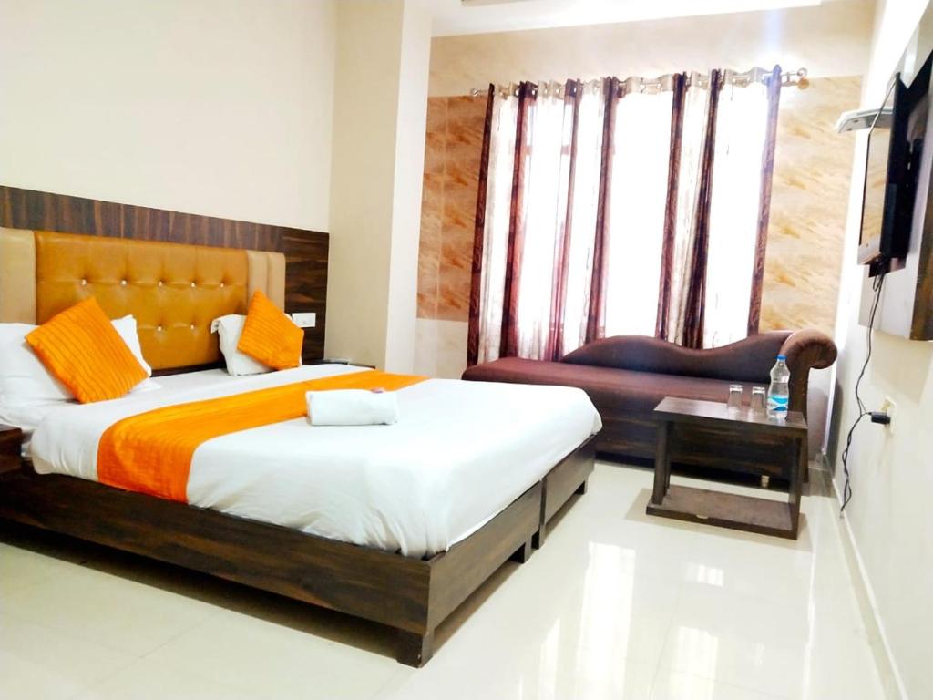 a bedroom with a large bed and a chair at Hotel Sukhman Residency in Amritsar