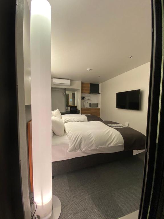 Postel nebo postele na pokoji v ubytování Hotel 草石庵