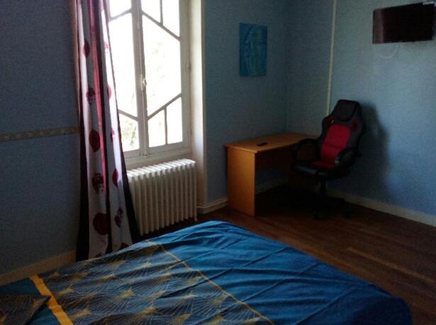 a bedroom with a bed and a window and a chair at le peterpan in Angliers