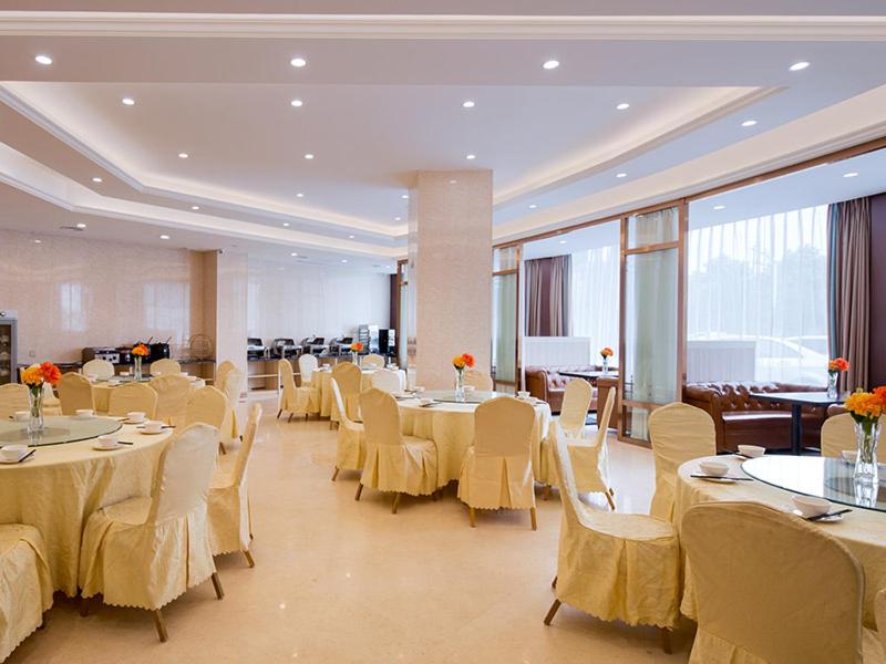a banquet hall with tables and white chairs and tablesearcher at Vienna Hotel(Changshu Sitir Store) in Zhangshu