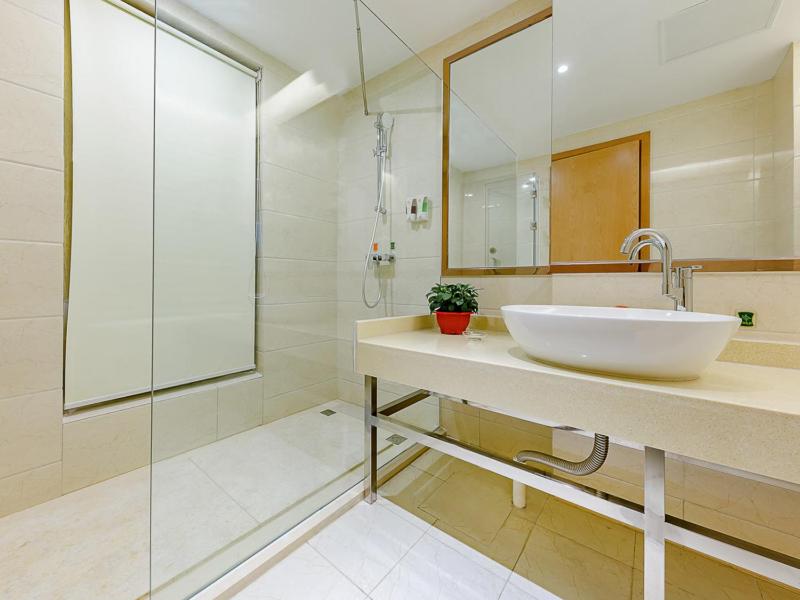 een badkamer met een witte wastafel en een douche bij Vienna Hotel Jinan West Railway Station Lanxiang Road Quanli Auto Parts City Shop in Jinan