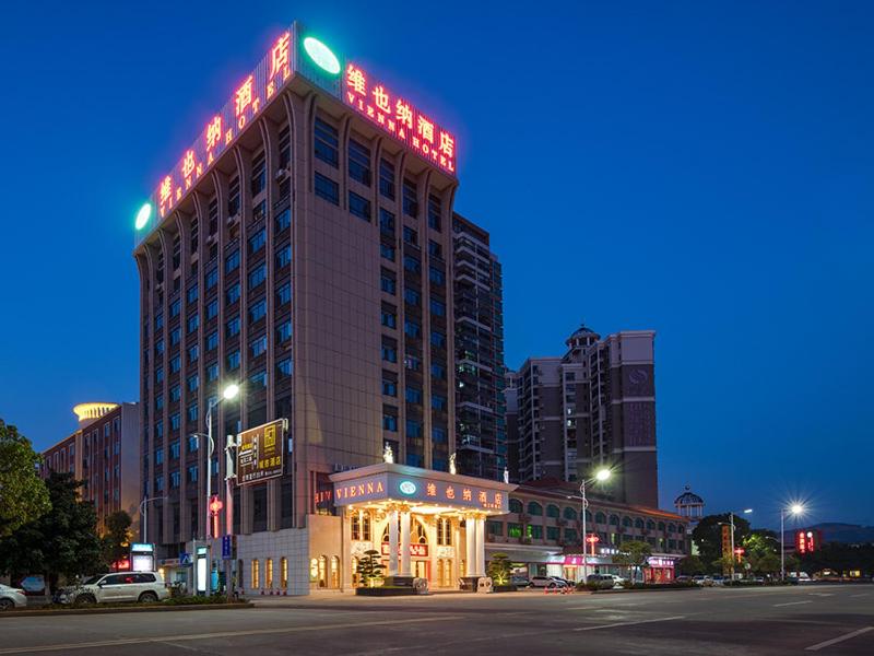 a tall building with a sign on top of it at Vienna Hotel (Shaoguan Qujiang Shunjing) in Shaoguan