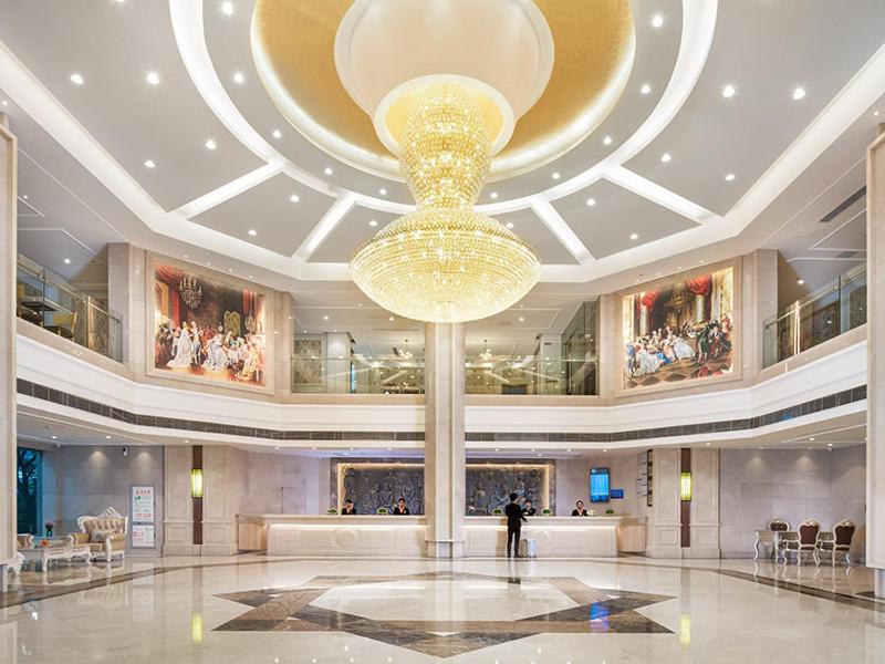 Vienna International Hotel(Hangzhou Xihu Fengshan Road Station) في هانغتشو: لوبي كبير وثريا كبيرة في مبنى