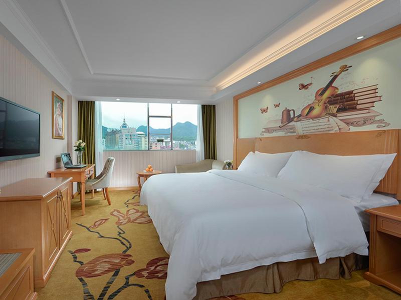 una camera da letto con un grande letto bianco e una grande finestra di Vienna Classic hotel(Lianzhou Building Branch) a Lianzhou