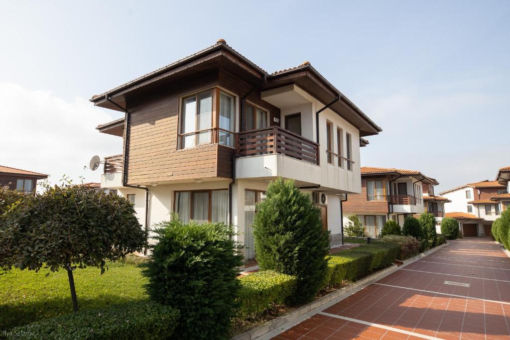 a large house with a balcony on a street at Villas in Complex Trakiyskiy Bryag in Lozenets