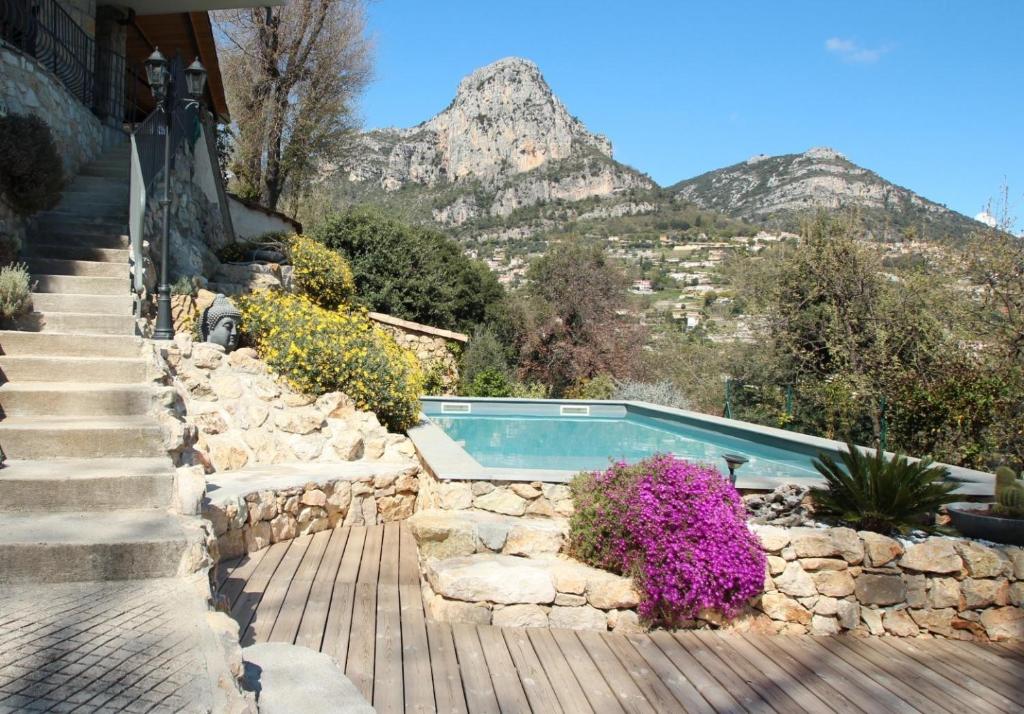 a swimming pool in a stone wall with a mountain at Au Pied des Baous in Vence