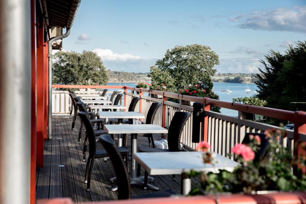 une rangée de tables sur le balcon d'un restaurant dans l'établissement Kyriad Saint-Malo Dinard, à La Richardais