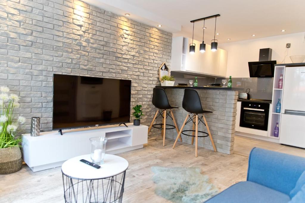 uma cozinha e sala de estar com uma grande televisão de ecrã plano em Asia em Nysa