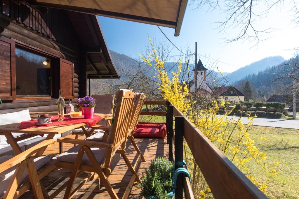 patio con mesa y sillas en el balcón en Pr' Vili Rozi, en Osilnica