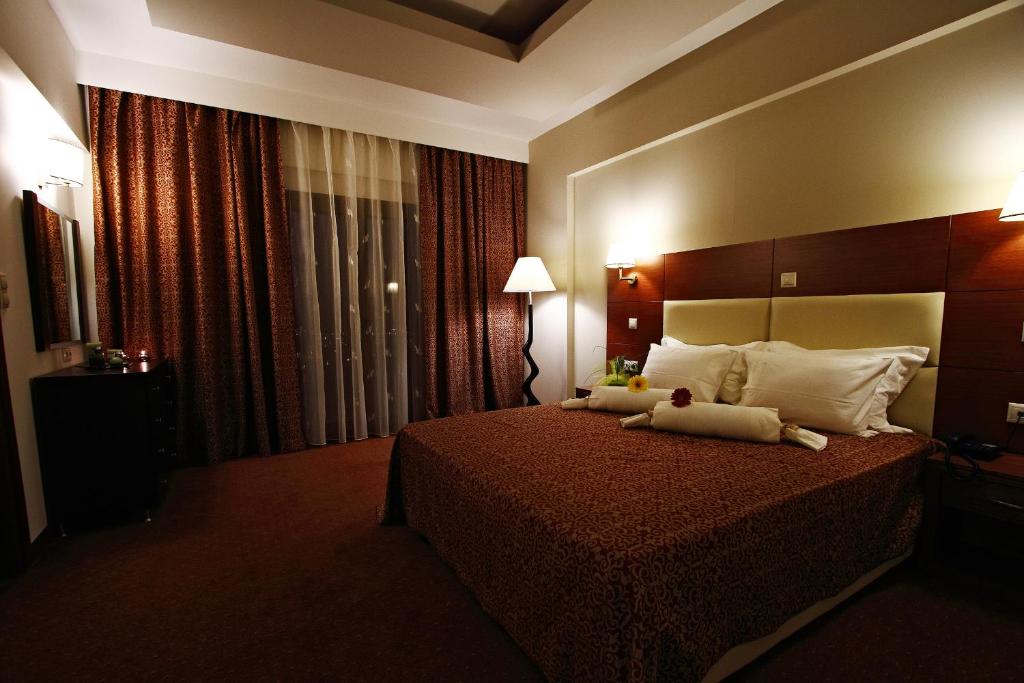 Una habitación de hotel con una cama con dos animales de peluche. en Siris Hotel, en Serres