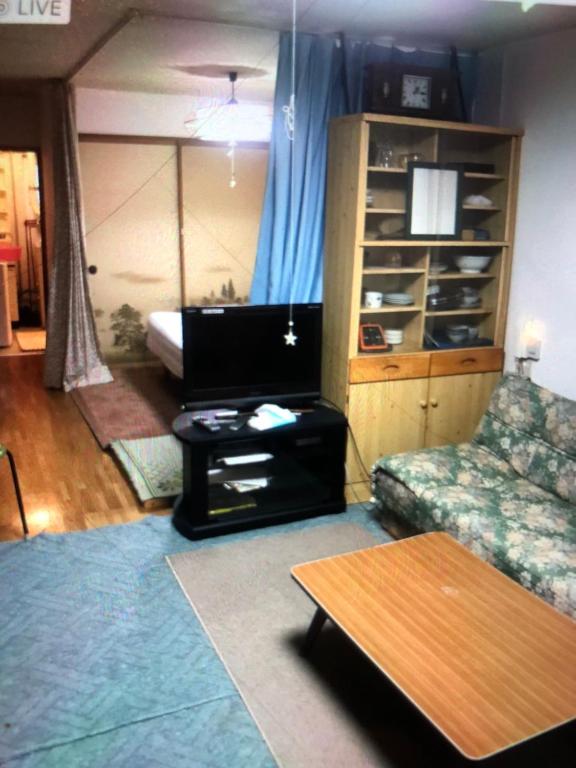 a living room with a couch and a table at Otaru stay in Otaru